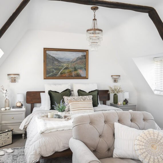Elegant attic conversion in the Cotswolds featuring exposed beams, soft layered textures, and natural light—interior design by a Cotswolds-based designer.