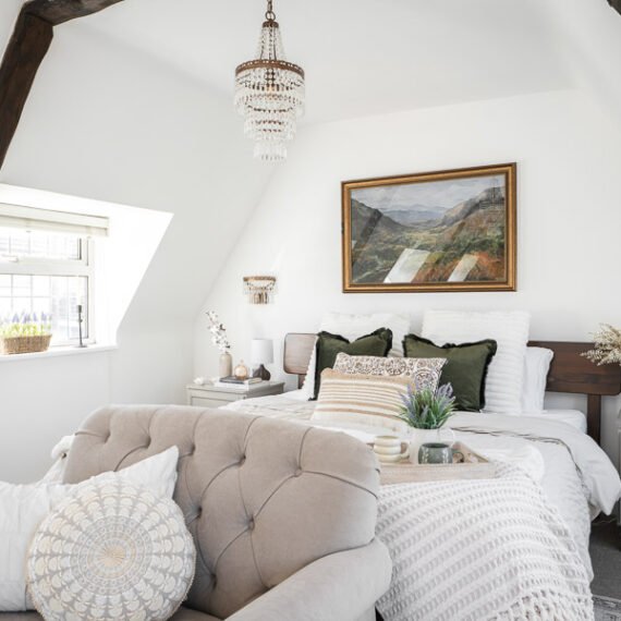 Elegant attic conversion in the Cotswolds featuring exposed beams, soft layered textures, and natural light—interior design by a Cotswolds-based designer.